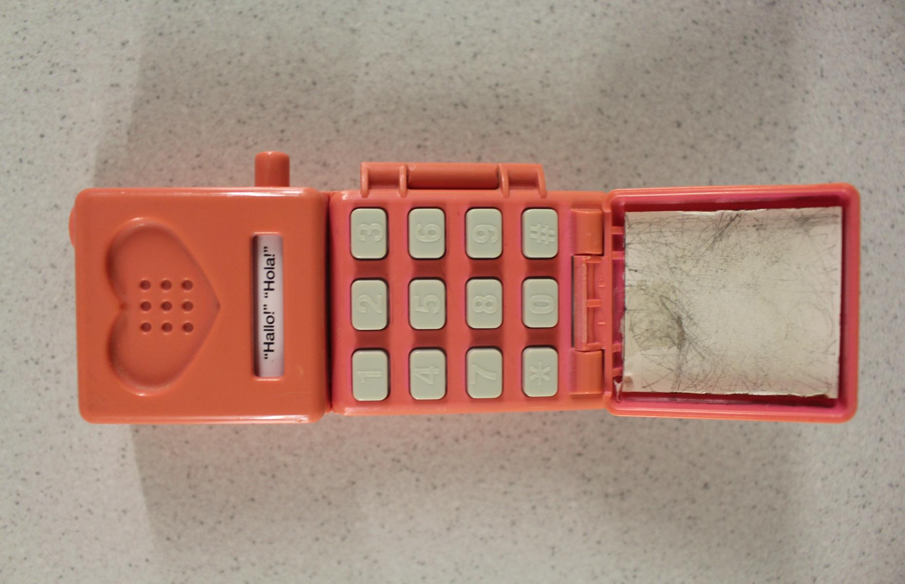 Aufgeklapptes pinkes Spielzeughandy.