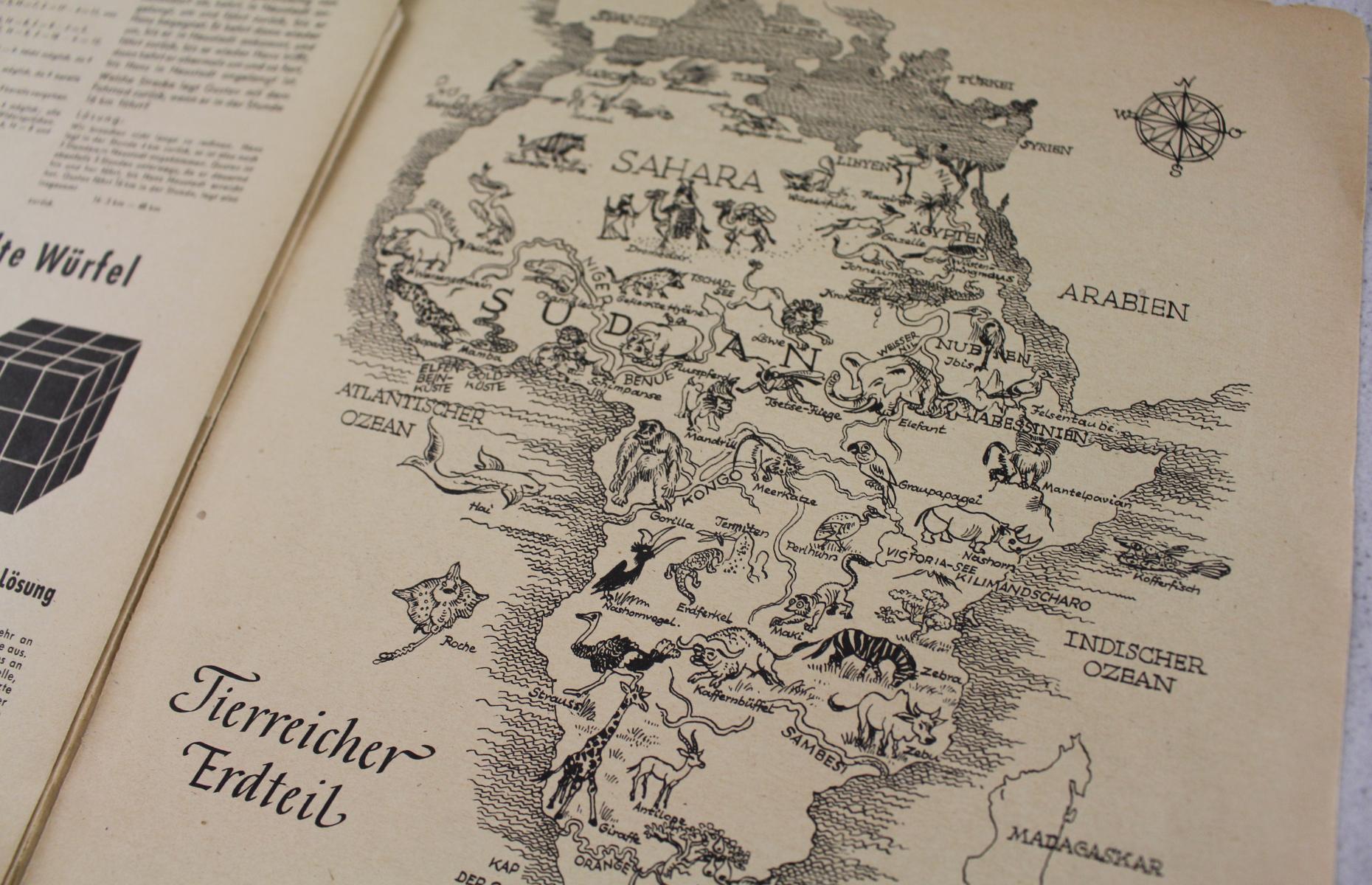 Abgebildet ist ein Landkarte Afrikas aus der Schulpost. Die Karte ist schwarz-weiß und mit mehreren Tieren verziert.