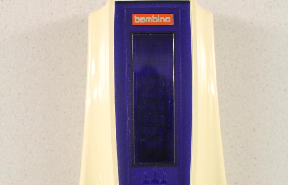 Hier ist der obere Teil des Ufo Master Blasters in weiß, mit einem blauen Mittelteil und Bildschirm zu sehen. Das Logo "Bambino" ist orange. 